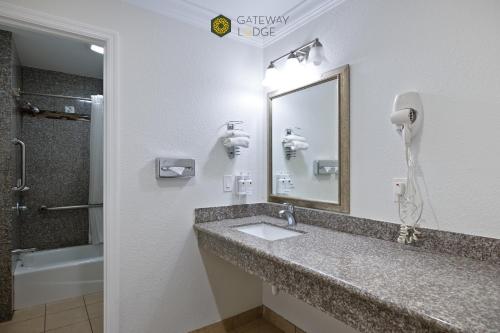 a bathroom with a sink and a mirror and a shower at Gateway Lodge in Seaside