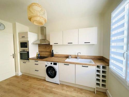 une cuisine avec un évier et une machine à laver dans l'établissement Grand appartement vue mer, à Sari-Solenzara