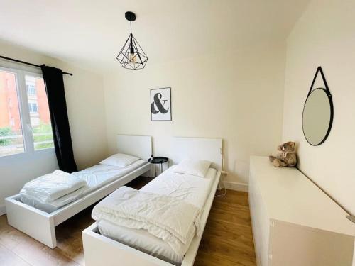 - 2 lits dans une chambre blanche avec un miroir dans l'établissement Grand appartement vue mer, à Sari-Solenzara