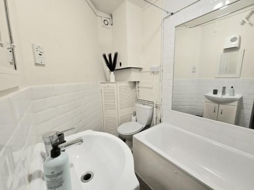 a white bathroom with a sink and a toilet at 2BD Kings Cross & St Pancras Elegance in London
