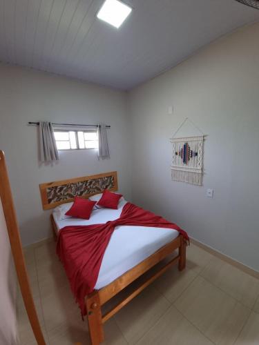 a bedroom with a bed with red pillows at Pouso da Kakau in Pirenópolis