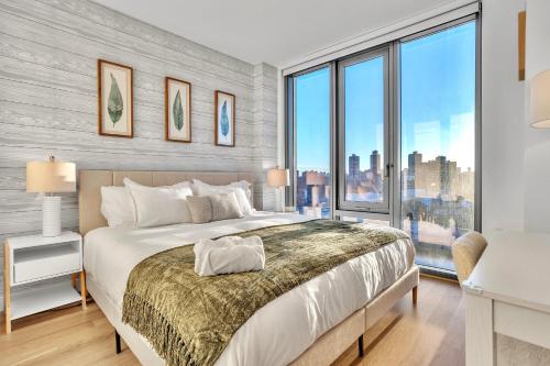 a bedroom with a large bed and large windows at Prime NYC Waterfront Gem in Mott Haven
