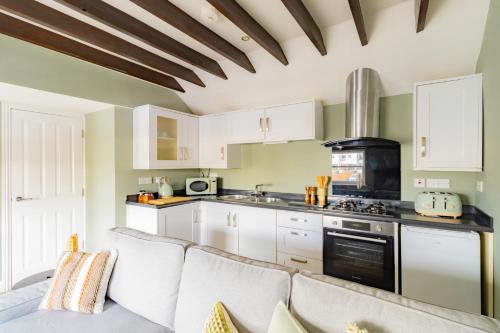a kitchen with white cabinets and a couch at St James Lodge in Cheltenham