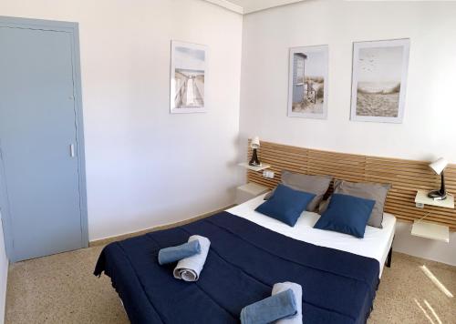 a bedroom with a large bed with blue sheets and pillows at Apartamento El Sol in Piles