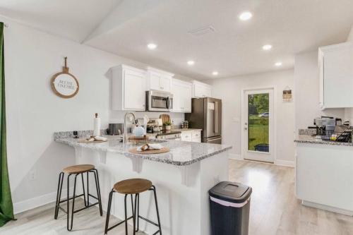 a kitchen with a counter and two stools at Retreat at the Oasis in Pensacola