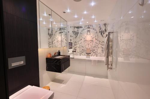 een badkamer met een douche, een wastafel en een toilet bij Luxury-high street Kensington-spacious-hydePark in Londen
