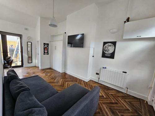 a living room with a couch and a tv at Charming House in City Centre in Dublin
