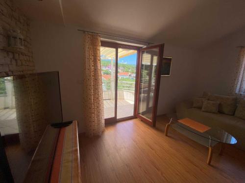 a living room with a couch and a large window at Apartment With the Sea View in Basina