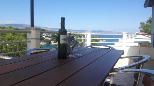 Una botella de vino sentada en una mesa de madera con copas en Apartment With the Sea View en Basina
