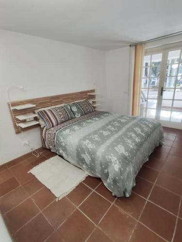 a bed sitting on a tiled floor in a bedroom at Lara's Green Home in Quercianella