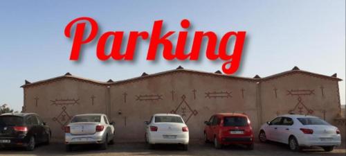 a sign that reads parking in front of a building at Luxury Bedouin Camp in Merzouga