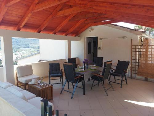 a patio with a table and chairs and a couch at Apartman Marina sa parkingom in Jelsa