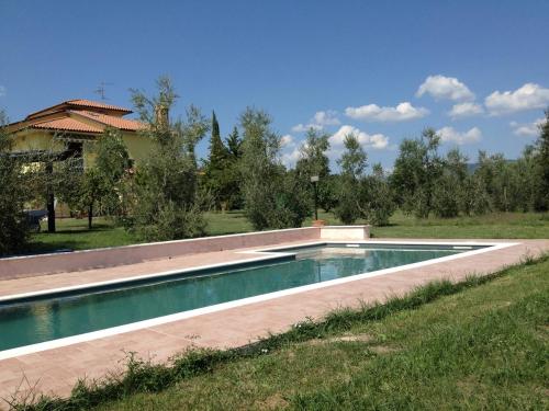 a swimming pool in a yard next to a house at La Casa Nell'Oliveto Bed & Breakfast in Acquasparta