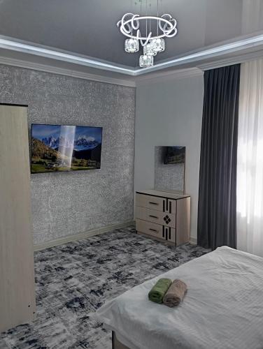 um quarto com uma cama e um lustre em MAR.s em Bukhara