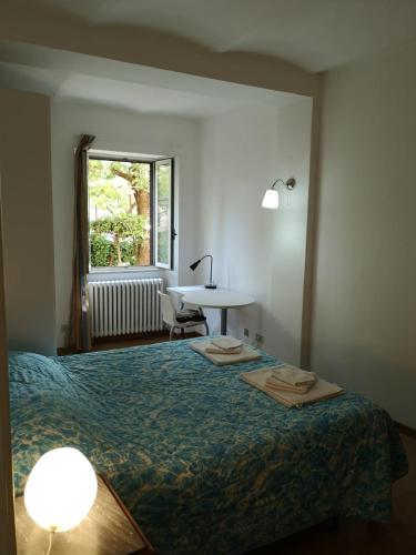 a bedroom with a bed and a desk and a window at xx settembre House in the city with Garden in Perugia