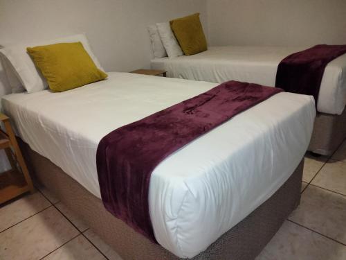 two beds in a hotel room withskirts at Apartment on MR103 in Mbabane