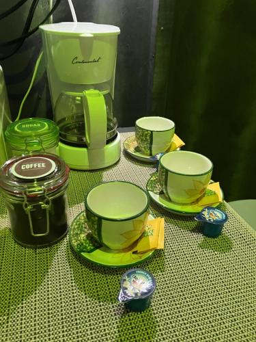 a table with green coffee cups and a blender at Junzi in Ceiba