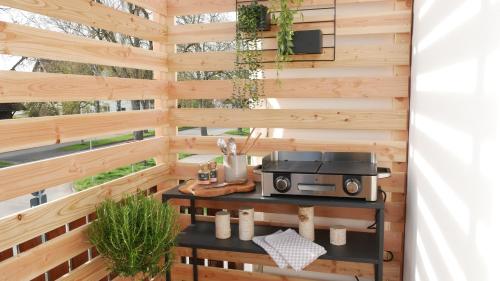 an outdoor kitchen with a wooden wall at Plant Apartment - Großer Balkon mit Grill - Schwarzwald und Schwäbische Alb in Eutingen
