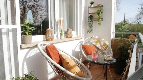porche con sillas, mesa y ventana en Plant Apartment en Eutingen
