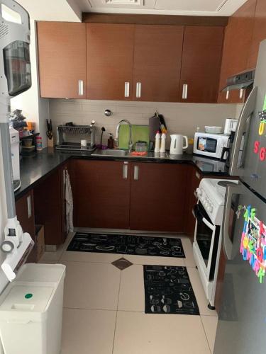 a kitchen with brown cabinets and a stove top oven at The cozy apartment in Abu Dhabi