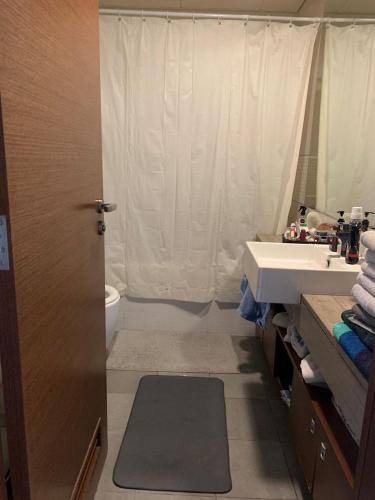 a bathroom with a sink and a toilet and a mirror at The cozy apartment in Abu Dhabi