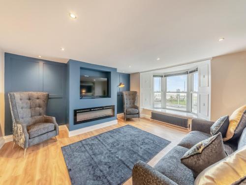 a living room with a couch and chairs and a tv at Captain's Quarters in Seaton Carew