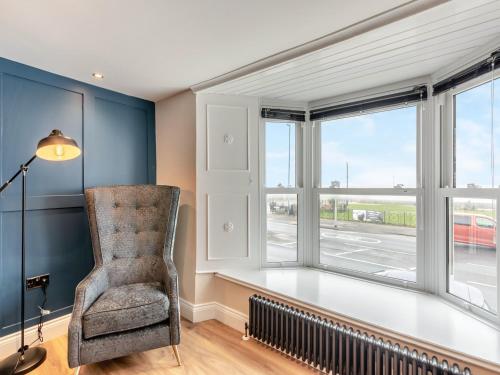 a living room with a chair and a window at Captain's Quarters in Seaton Carew