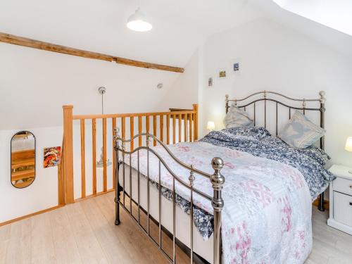 a bedroom with a bed and a wooden floor at Bumpers Stable in Derwydd