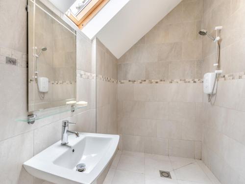 ein Bad mit einem Waschbecken und einem Spiegel in der Unterkunft Bumpers Stable in Derwydd
