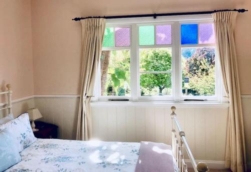 a bedroom with a bed and a window at Maple Hill Cottage in Castle Forbes Bay