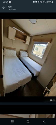 Duas camas num pequeno quarto com uma janela em Oakley em Rookley
