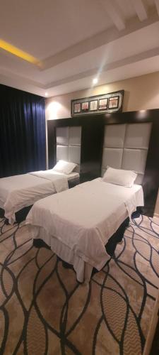 ein Hotelzimmer mit 2 Betten und Teppichboden in der Unterkunft مهاد للشقق المخدومه in Najran