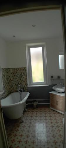 duża łazienka z wanną i oknem w obiekcie Manoir de la Saône w mieście Seurre