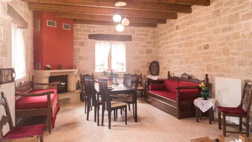 a living room with a table and chairs and a couch at Drys Stone House in Miriokéfala