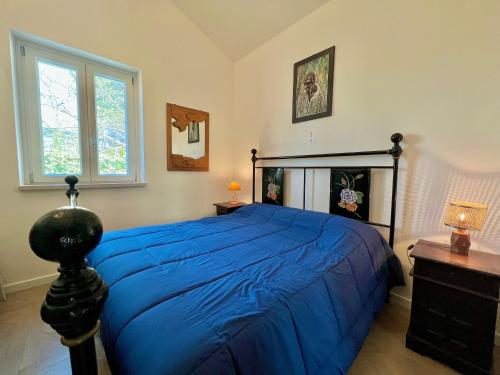 Deliziosa villetta nuova vista lago في Labro: غرفة نوم بسرير ازرق ونافذة