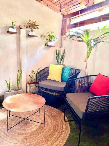 um pátio com duas cadeiras e uma mesa e algumas plantas em Sweet home Ixtapa comfort em Ixtapa