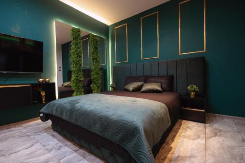 Un dormitorio con una cama grande con paredes azules. en SpaNish apartman 2., en Niš