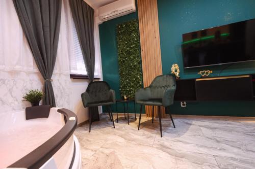 1 dormitorio con 2 sillas, mesa y TV en SpaNish apartman 2., en Niš
