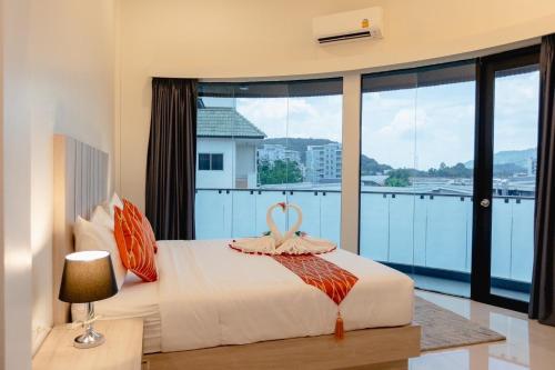 a bedroom with a bed and a large window at SUBANAN Residence - SHA Extra Plus Certified in Ban Kohong