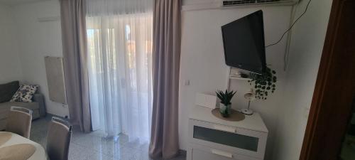 a living room with a flat screen tv on a wall at Apartments Ćosic in Grebaštica