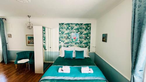a bedroom with a green bed with a painting on the wall at Marcel Zadar City Center in Zadar