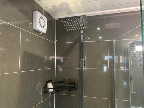 La salle de bains est pourvue d'une douche avec une porte en verre. dans l'établissement Cosy Semi-Detached House To Stay In West Yorkshire, à Heckmondwike