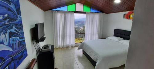 a bedroom with a bed and a stained glass window at Altovento Sutamarchán in Sutamarchán