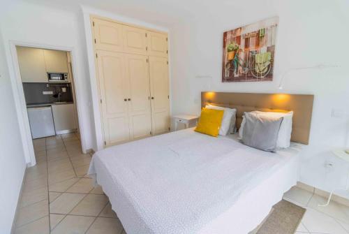 a bedroom with a large white bed with yellow pillows at Casas Novas Guesthouse - Adults Only in Lagos