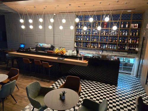 a restaurant with a bar with tables and chairs at Hotel Vojvoda Putnik in Vranje