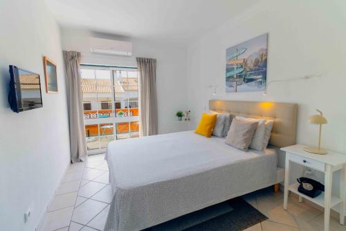 a bedroom with a bed and a window at Casas Novas Guesthouse - Adults Only in Lagos