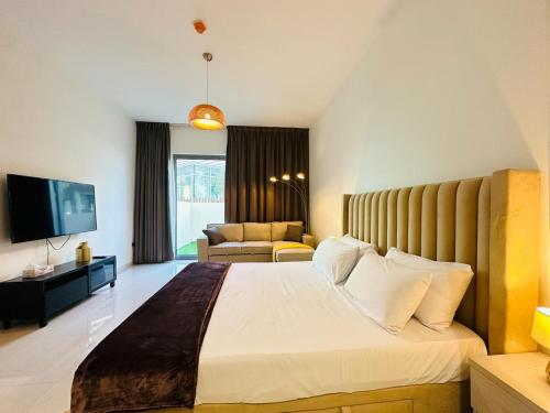 una camera con un grande letto e un soggiorno di Luxurious studio apartment with private garden a Sharjah