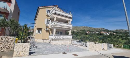 a large building with white balconies on top of it at Apartments Ćosic in Grebaštica