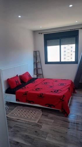 sypialnia z czerwonym łóżkiem i oknem w obiekcie Fernand ville Oran w mieście Oran