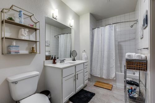 a white bathroom with a toilet and a sink at Gorgeous Riverwalk View Condo 1241 in San Antonio